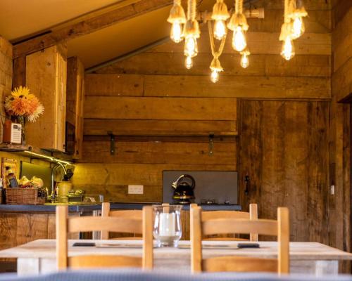 a dining room with a table and chairs in a kitchen at Luxury Safari Lodge surrounded by deer!! 'Fallow' in Crediton