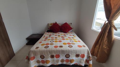 a bedroom with a bed with a polka dot blanket at Habitación en casa in Pereira