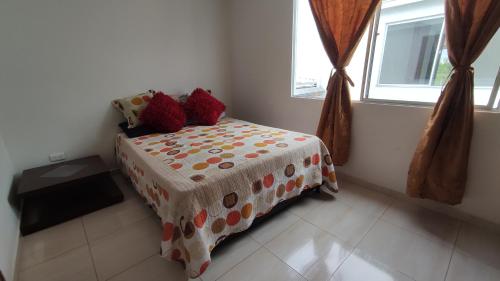 a bedroom with a bed with a polka dot blanket at Habitación en casa in Pereira