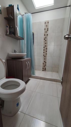 a bathroom with a toilet and a sink and a shower at Habitación en casa in Pereira