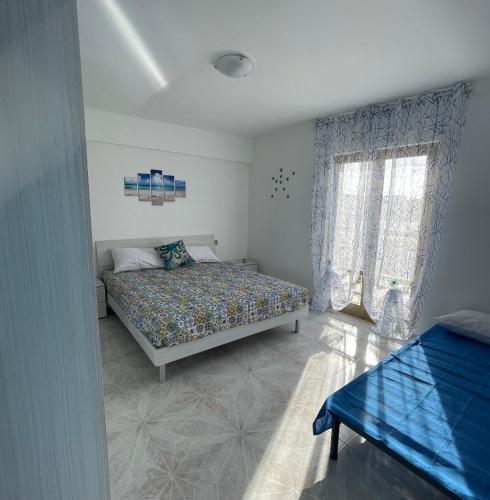 a bedroom with a bed and a window at Casa Scirocco in Balestrate