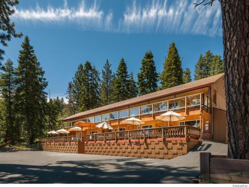 a building with tables and umbrellas in front of it at Cedar Glen Lodge in Tahoe Vista