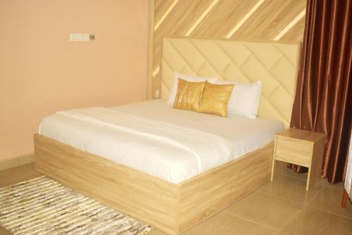 - une chambre avec un lit doté d'un cadre en bois dans l'établissement Opal Ville Bamboo Suite, 2-bedroom in a serene area, à Abuja