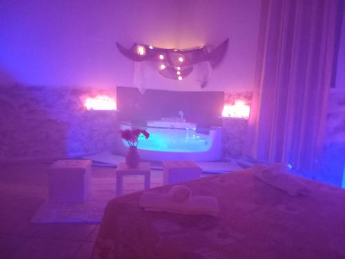 a room with a bed and a tub with purple lights at Villa Laura Apartment in Giardini Naxos