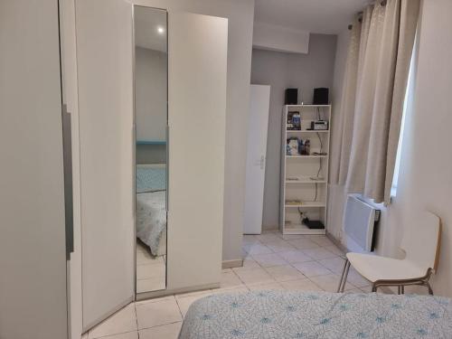- une chambre avec un miroir, un lit et une chaise dans l'établissement Cosy Apartments - Marseille Panier - City center, à Marseille