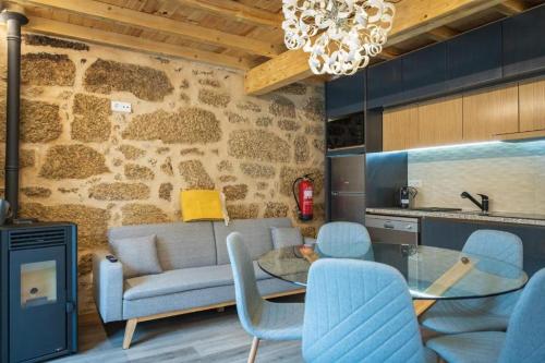uma sala de estar com um sofá, uma mesa e cadeiras em Casas Puro Granito em Sabugueiro