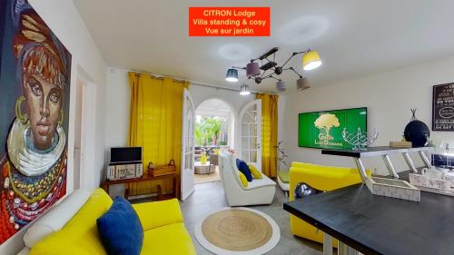 a living room with a yellow couch and a tv at GREEN LORD DOMAINE - Lodges Piscine & Spa - Bar & Lounge - Restaurant gastronomique in Lamentin