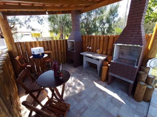 a patio with a wood stove and a table and chairs at Aloha Cabanas - Cabana O'ahu in Balneário Gaivotas