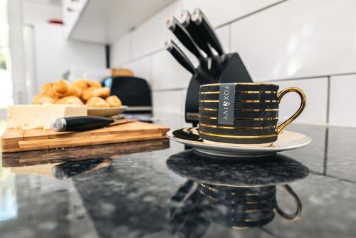 a cup of coffee on a table with a plate of doughnuts at 3 Bedrooms house ideal for long Stays! in Southampton