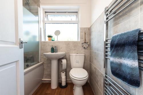 a small bathroom with a toilet and a sink at 3 Bedrooms house ideal for long Stays! in Southampton