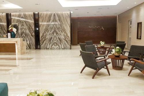 a lobby with chairs and tables and a wall at StayInMyCondo - 8th Condo in Pasay near NAIA Airport, MOA Pasay in Manila