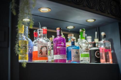 un montón de botellas de alcohol sentadas en un estante en The Crown en Uppingham
