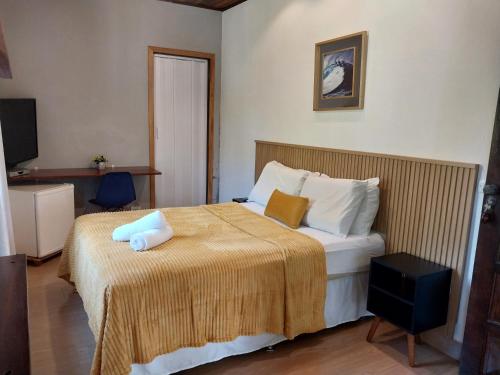 een hotelkamer met een bed en een televisie bij Pousada Schueng in Trindade