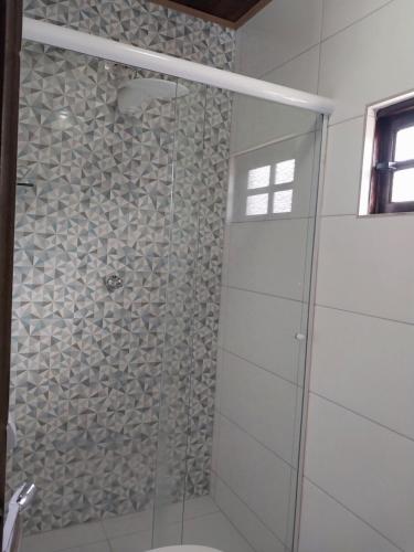 a shower with a glass door in a bathroom at Pousada Schueng in Trindade