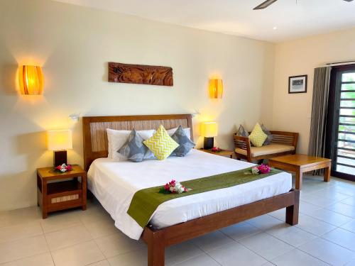 a bedroom with a large bed with flowers on it at Nasama Resort in Port Vila