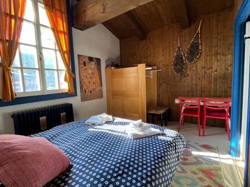 a bedroom with a bed and a table with red chairs at Tuckett Lodge - A large flat for families and groups of friends in Madonna di Campiglio