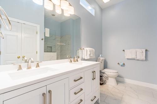 a white bathroom with a sink and a toilet at Jenny Lind East - Nordic Villas in Orange Beach