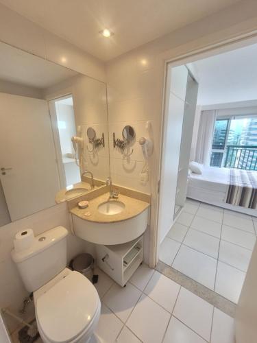 a bathroom with a toilet and a sink and a mirror at Vision Executive, Brasília in Brasília