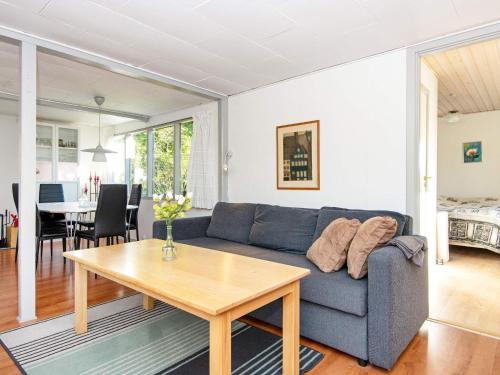 a living room with a blue couch and a table at 6 person holiday home in Ebeltoft in Ebeltoft