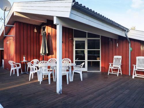 um pátio com uma mesa e cadeiras num deque em 10 person holiday home in Jerup em Jerup