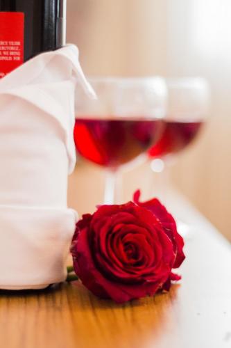 a glass of wine and a red rose on a table at Feyza Apart in Istanbul