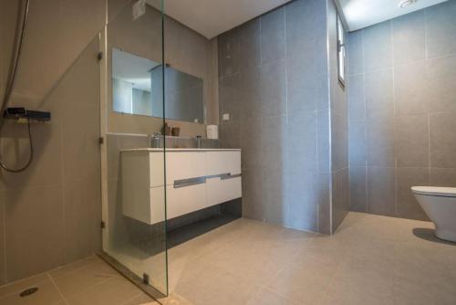 a bathroom with a glass shower and a toilet at Taghazoutbay Résidence Tamourrit Appart in Taghazout