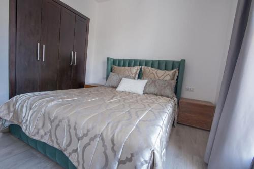 1 dormitorio con 1 cama grande y armario de madera en Taghazoutbay Résidence Tamourrit Appart en Taghazout