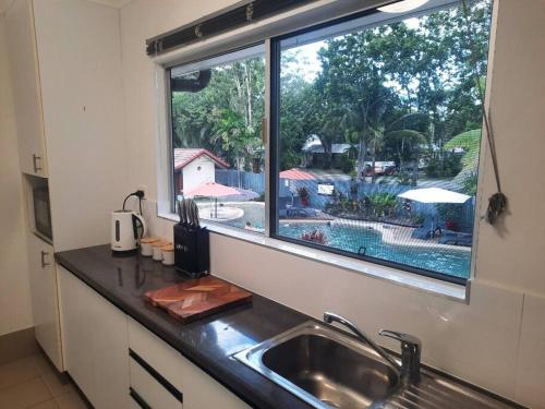 a kitchen counter with a sink and a window at Wanderer in Port Douglas
