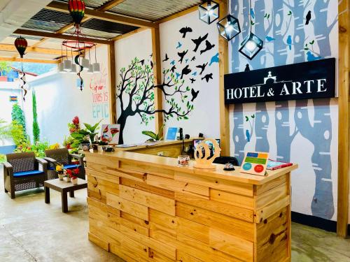 a lobby with a reception counter with birds on the wall at Hotel y Arte Antigua by Amazing Guatemala Travel in Antigua Guatemala