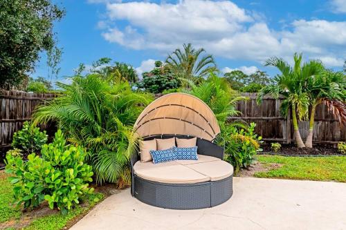 a wicker chair in a yard with a fence at Private Backyard Oasis! Hot Tub & Salt Water Pool! in Sarasota
