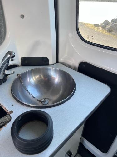 a bathroom with a metal sink and a toilet at Cheap Camper Van in Iceland in Reykjavík