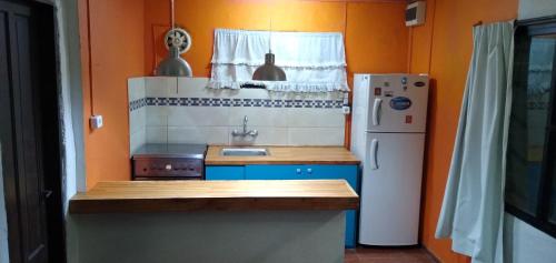 una pequeña cocina con fregadero y nevera. en Pico Azul, en La Paloma