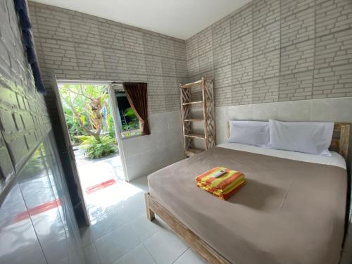 a bedroom with a large bed and a window at Guest House Home 46 Bali in Canggu
