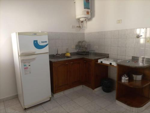 cocina con refrigerador blanca y armarios de madera en EL PINAR, en Federación