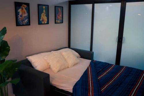 a room with a bed with white pillows on it at Aloha Hale One Oasis Cdo in Cagayan de Oro