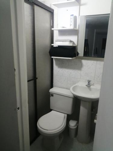 a small bathroom with a toilet and a sink at San Diego aparta estudios in Medellín