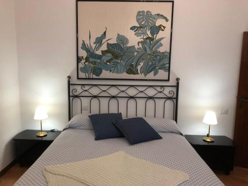 - une chambre avec un lit avec deux lampes et un tableau dans l'établissement La Poderina, à Monteriggioni