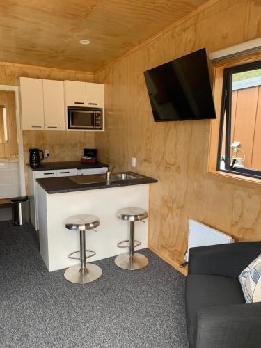 una cocina con encimera y taburetes en una caravana en Motuoapa Bay Holiday Park, en Turangi