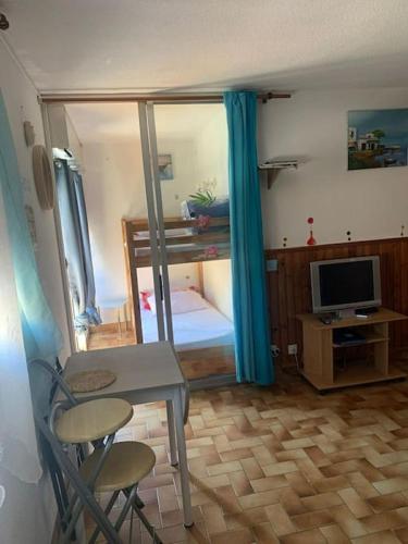 Cette chambre comprend une chambre avec un bureau et une télévision. dans l'établissement Studio Plage 200m Parking gratuit Port la Nouvelle, à Port-la-Nouvelle