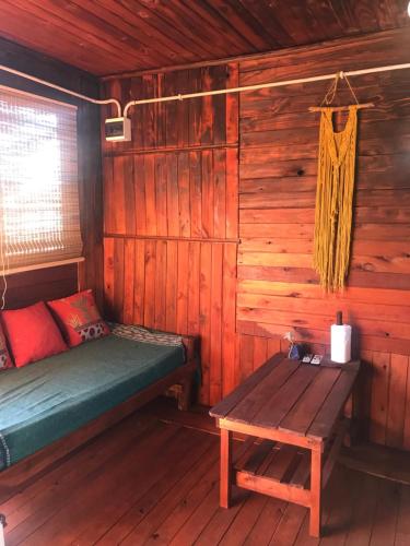 Holzhütte mit einem Bett und einem Holztisch in der Unterkunft Campo Verde in Concordia