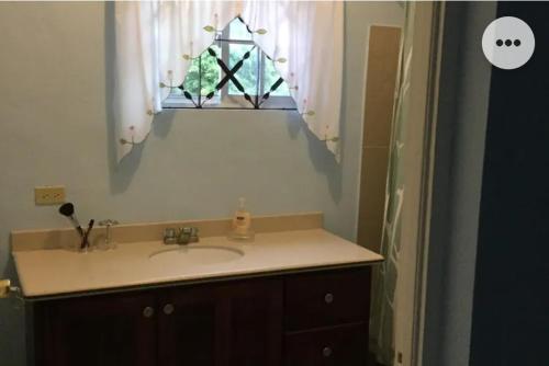a bathroom with a sink and a window at A Piece of Paradise in Content