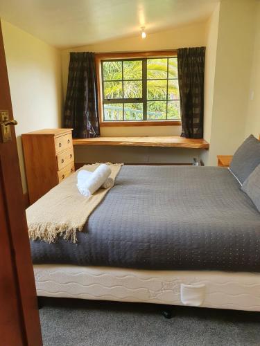 a bedroom with a large bed and a window at Ludstone Villa - A charming family home in Kaikoura