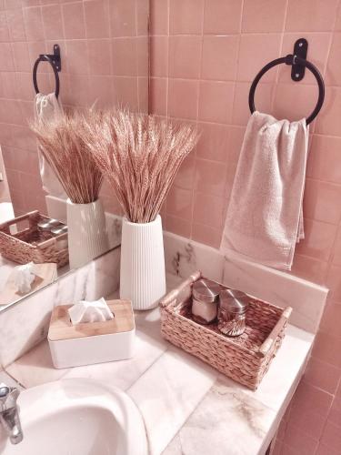 a bathroom with two vases and baskets on a sink at Rumah Penangkap Mimpi in Kertih