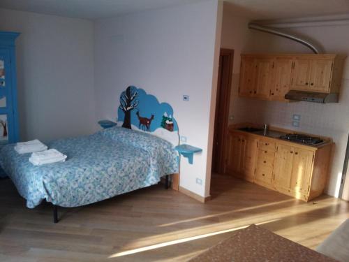 a bedroom with a bed with a blue comforter at Agriturismo Prato degli Angeli in Sassoleone