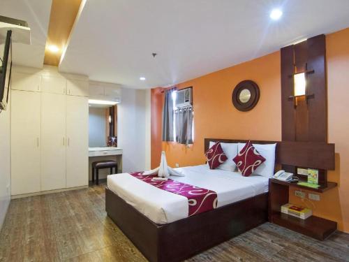 ein Schlafzimmer mit einem großen Bett in einem Zimmer in der Unterkunft ACL Suites in Manila