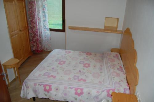 a small bedroom with a bed with a pink blanket at Agriturismo Prato degli Angeli in Sassoleone