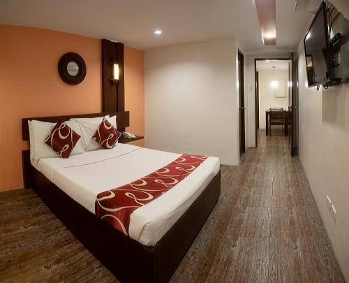 Habitación de hotel con cama y TV en ACL Suites, en Manila