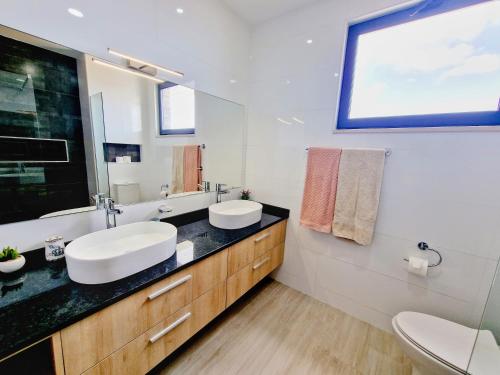 La salle de bains est pourvue d'un lavabo et d'un miroir. dans l'établissement Apartamento encantador com piscina e vista mar, à Praia
