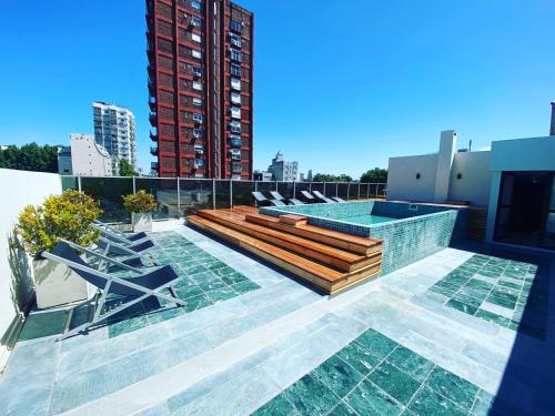 a rooftop patio with chairs and a pool on a building at First Palermo Hotel in Buenos Aires