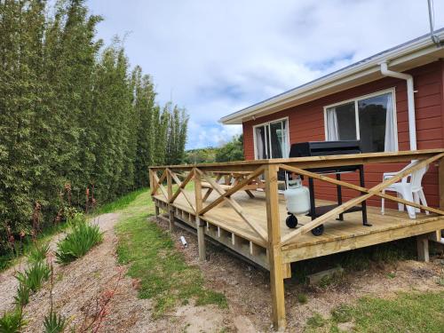 a wooden deck on the side of a house at Whalers retreat in Pukenui